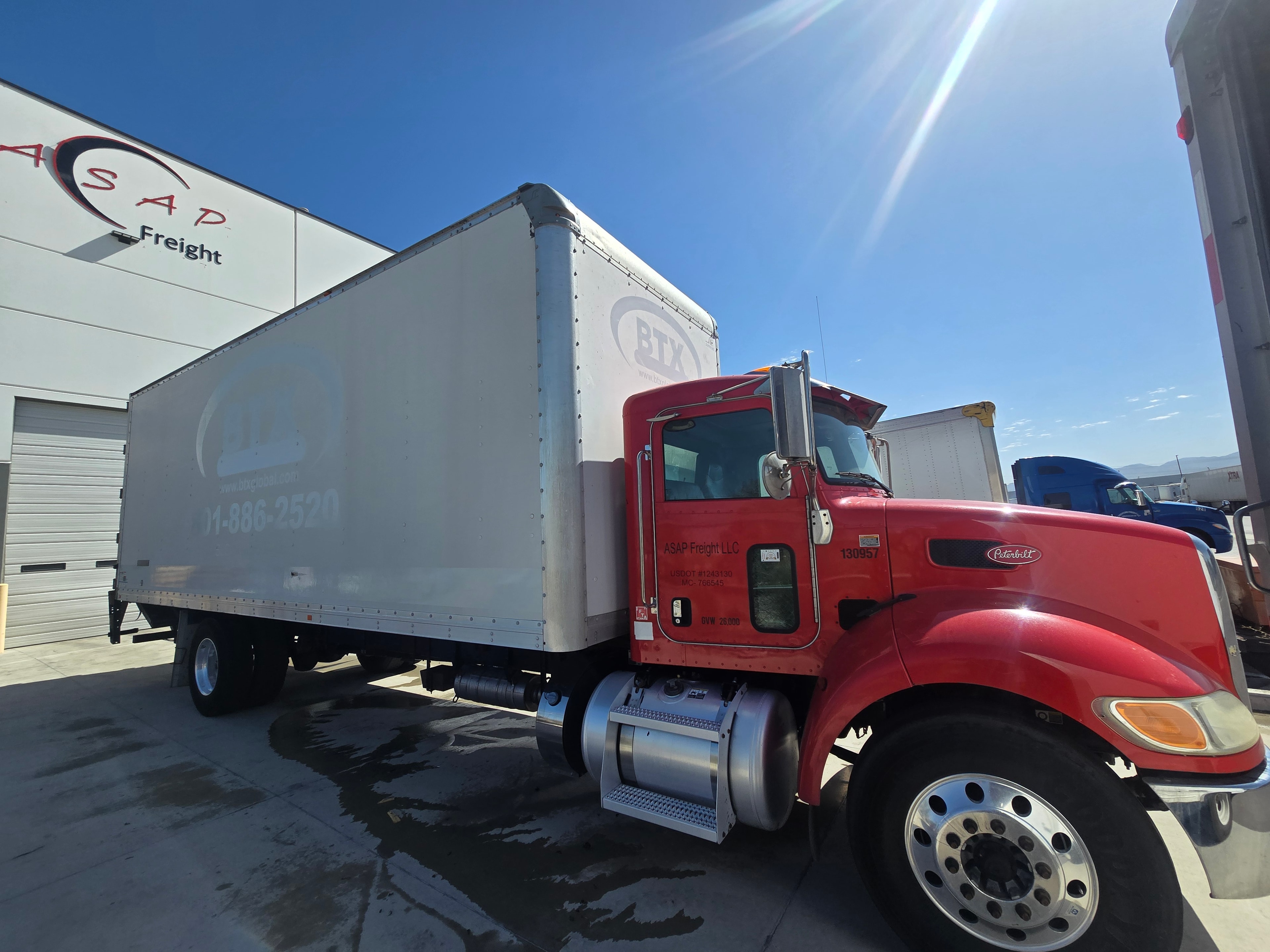 BTX Global Logistics Peterbilt box truck — rear three-quarter view after decal removal at ASAP Freight facility