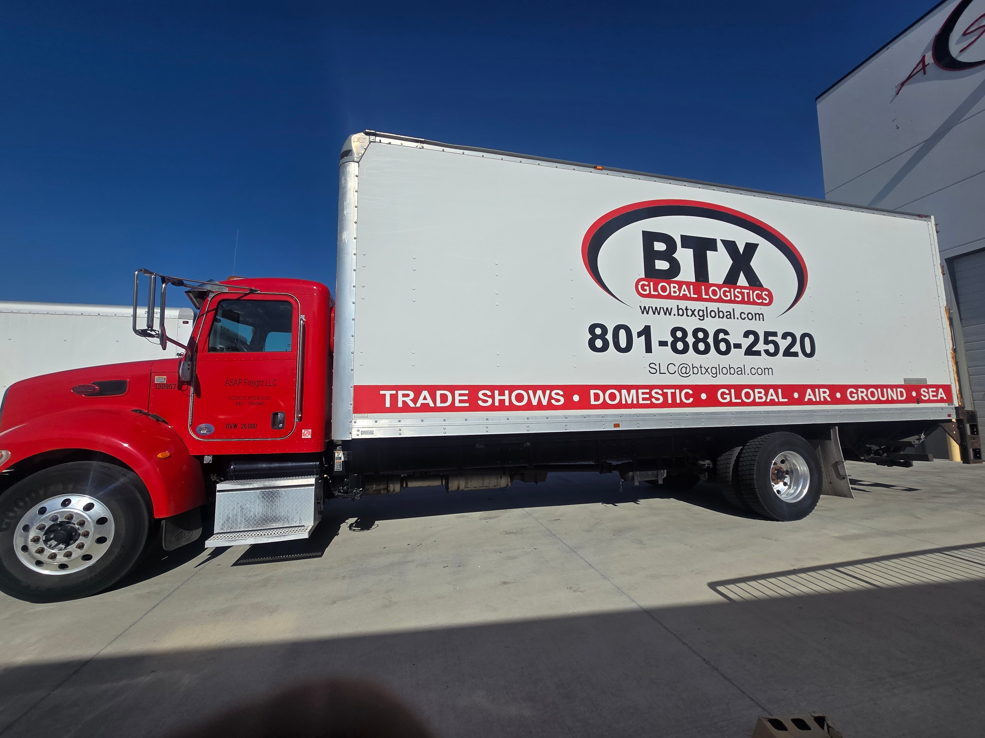 BTX Global Logistics Peterbilt box truck — full side profile showing vinyl graphics before decal removal
