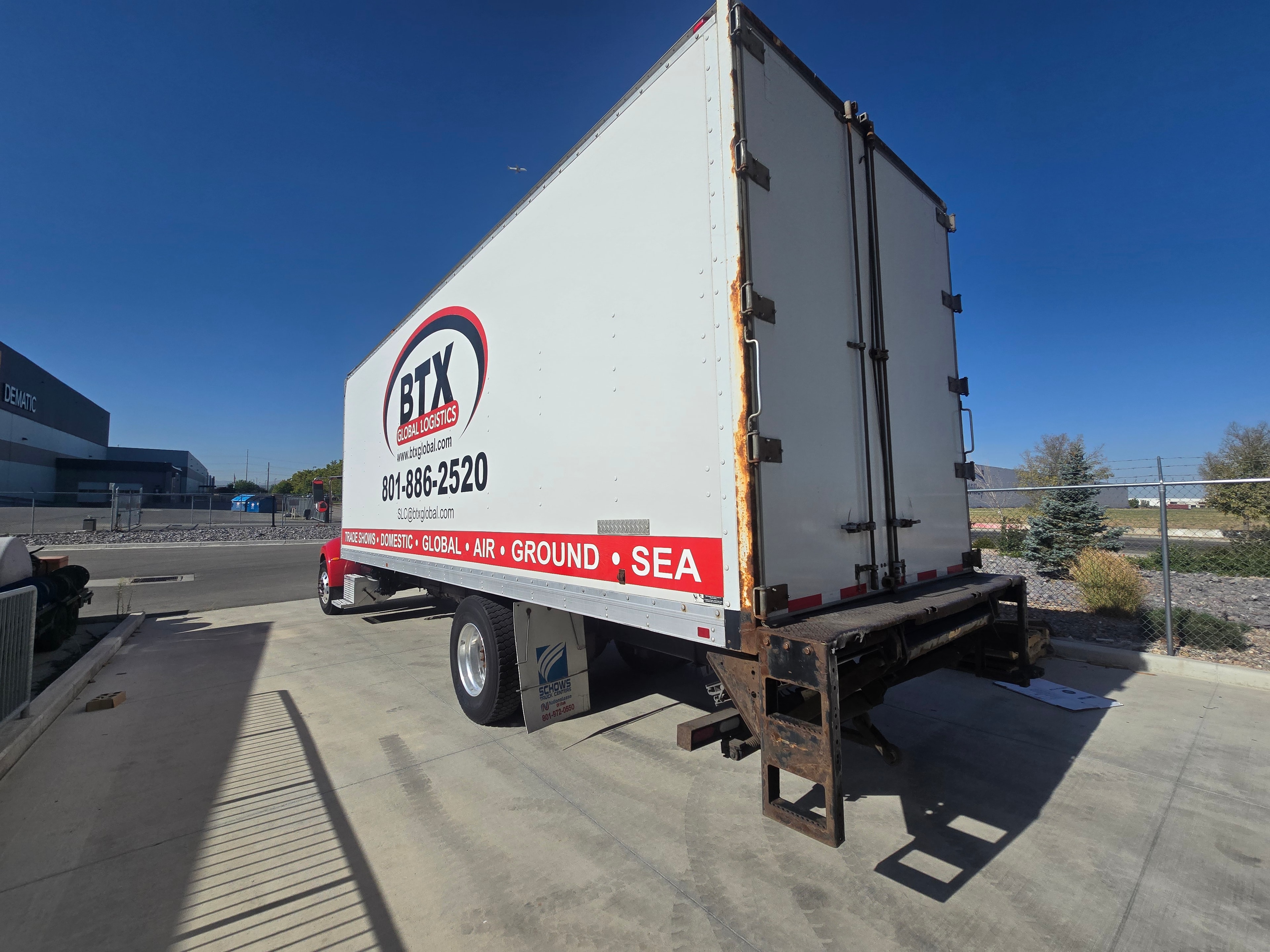 BTX Global Logistics box truck rear doors — vinyl graphics and rust on liftgate before removal