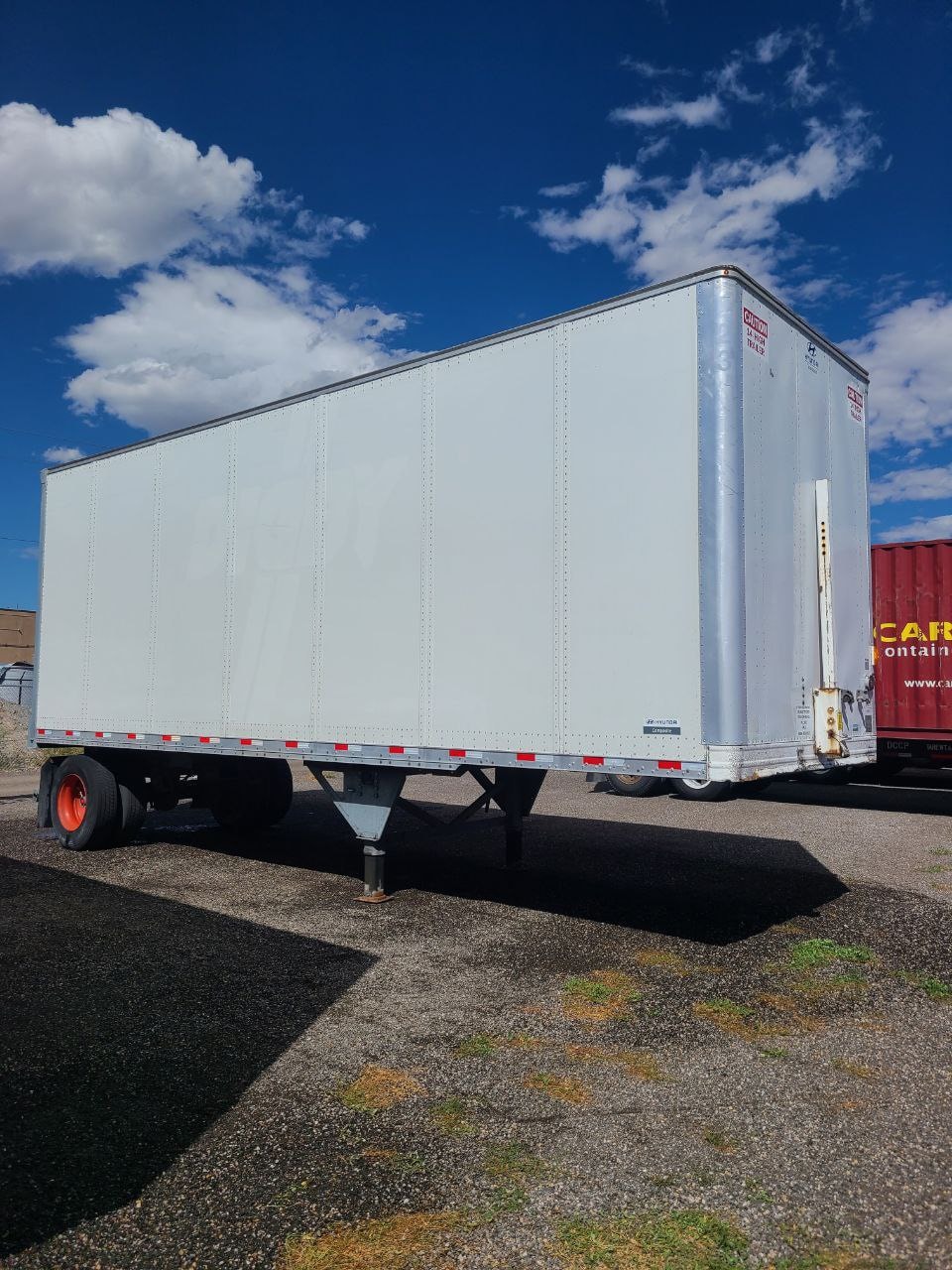Single Digby pup trailer after full decal removal and pressure washing — clean white side panel against blue sky, fleet de-identification service Salt Lake City Utah